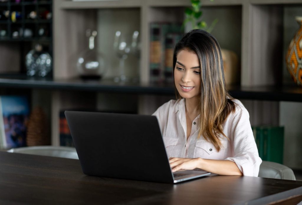 marketing de conteúdo: jovem mulher usando computador em sala bem decorada